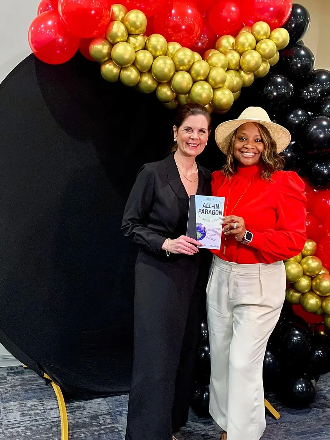 Carole Mendoza at a book event with a reader holding All-In Paragon
