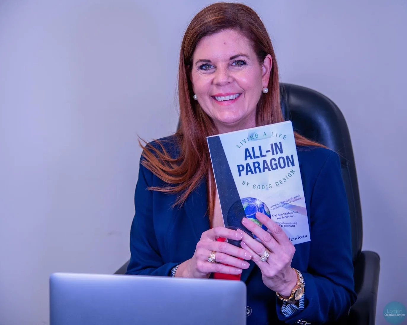 Carole Mendoza holding her book All-In Paragon